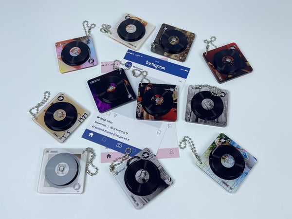 A collection of 11 square acrylic keychains featuring spinning miniature vinyl records and different aesthetic album artwork on a white background.