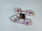 Clear earbud case filled with red and pink liquid glitter, attached to a gold cat-shaped clip and a miniature vinyl record keychain.
