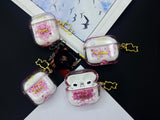 Clear earbud case filled with red and pink liquid glitter, attached to a gold cat-shaped clip and a miniature vinyl record keychain.