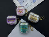 Clear earbud case filled with red and pink liquid glitter, attached to a gold cat-shaped clip and a miniature vinyl record keychain.