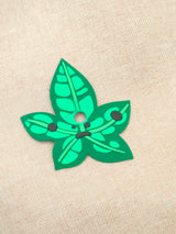 Six interchangeable green silicone leaf masks for a customizable earbud case, featuring heart, star, butterfly, and whisker shapes.