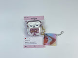 Clear earbud case filled with pink liquid glitter, attached to a gold cat-shaped clip and a miniature vinyl record keychain.