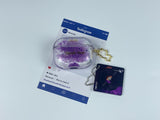 Clear earbud case filled with royal purple liquid glitter, attached to a gold cat-shaped clip and a miniature vinyl record keychain.