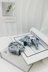 3D grey silicone earbud case shaped like a classic sci-fi spaceship freighter with detailed mechanical paneling.