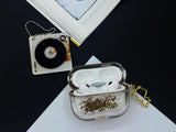 Clear earbud case filled with radiant gold liquid glitter, attached to a gold cat-shaped clip and a miniature vinyl record keychain.
