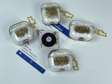 Clear earbud case filled with radiant gold liquid glitter, attached to a gold cat-shaped clip and a miniature vinyl record keychain.