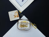 Clear earbud case filled with radiant gold liquid glitter, attached to a gold cat-shaped clip and a miniature vinyl record keychain.