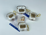 Clear earbud case filled with radiant gold liquid glitter, attached to a gold cat-shaped clip and a miniature vinyl record keychain.