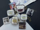 Clear earbud case filled with radiant gold liquid glitter, attached to a gold cat-shaped clip and a miniature vinyl record keychain.