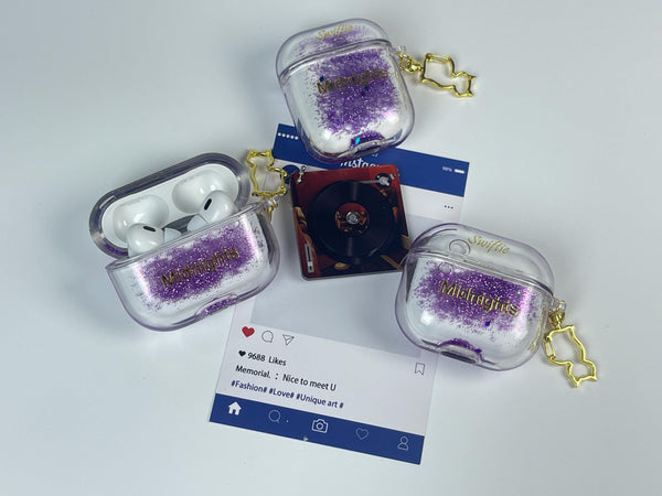 Clear earbud case filled with holographic lavender and blue liquid glitter, attached to a gold cat-shaped clip and a miniature vinyl record keychain.