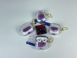 Clear earbud case filled with holographic lavender and blue liquid glitter, attached to a gold cat-shaped clip and a miniature vinyl record keychain.