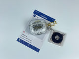 Clear earbud case filled with ghostly silver grayscale liquid glitter, attached to a gold cat-shaped clip and a miniature vinyl record keychain.