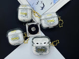 Clear earbud case filled with ghostly silver grayscale liquid glitter, attached to a gold cat-shaped clip and a miniature vinyl record keychain.