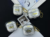 Clear earbud case filled with ghostly silver grayscale liquid glitter, attached to a gold cat-shaped clip and a miniature vinyl record keychain.