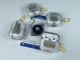 Clear earbud case filled with silver-grey liquid glitter, attached to a gold cat-shaped clip and a miniature vinyl record keychain.