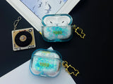 Clear, blue-tinted earbud case filled with iridescent blue liquid glitter, attached to a gold cat-shaped clip and a miniature vinyl record keychain.