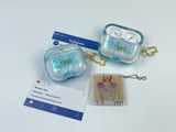 Clear, blue-tinted earbud case filled with iridescent blue liquid glitter, attached to a gold cat-shaped clip and a miniature vinyl record keychain.
