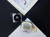 Clear earbud case filled with silver liquid glitter and tiny red stars, attached to a gold cat-shaped clip and a miniature vinyl record keychain.