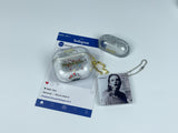 Clear earbud case filled with silver liquid glitter and tiny red stars, attached to a gold cat-shaped clip and a miniature vinyl record keychain.