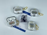 Clear earbud case filled with silver liquid glitter and tiny red stars, attached to a gold cat-shaped clip and a miniature vinyl record keychain.