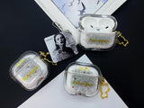 Clear earbud case filled with silver liquid glitter and tiny red stars, attached to a gold cat-shaped clip and a miniature vinyl record keychain.